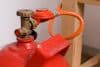 rote Propangasflasche mit Druckminderer und Schlauch