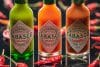 Drei Tabasco Flaschen und Chilis