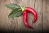 Zwei rote Chilischoten auf Holzhintergrund