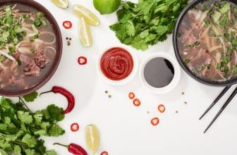 Ansicht von oben auf zwei Suppen in Schalen sowie zwei Saucen