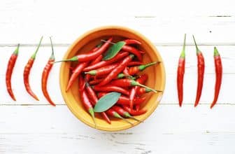 Scharfe rote Chili auf einem weißen hölzernen Vintage-Hintergrund.