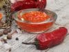 Glasschüssel mit Chilisauce, daneben rote Chilischote